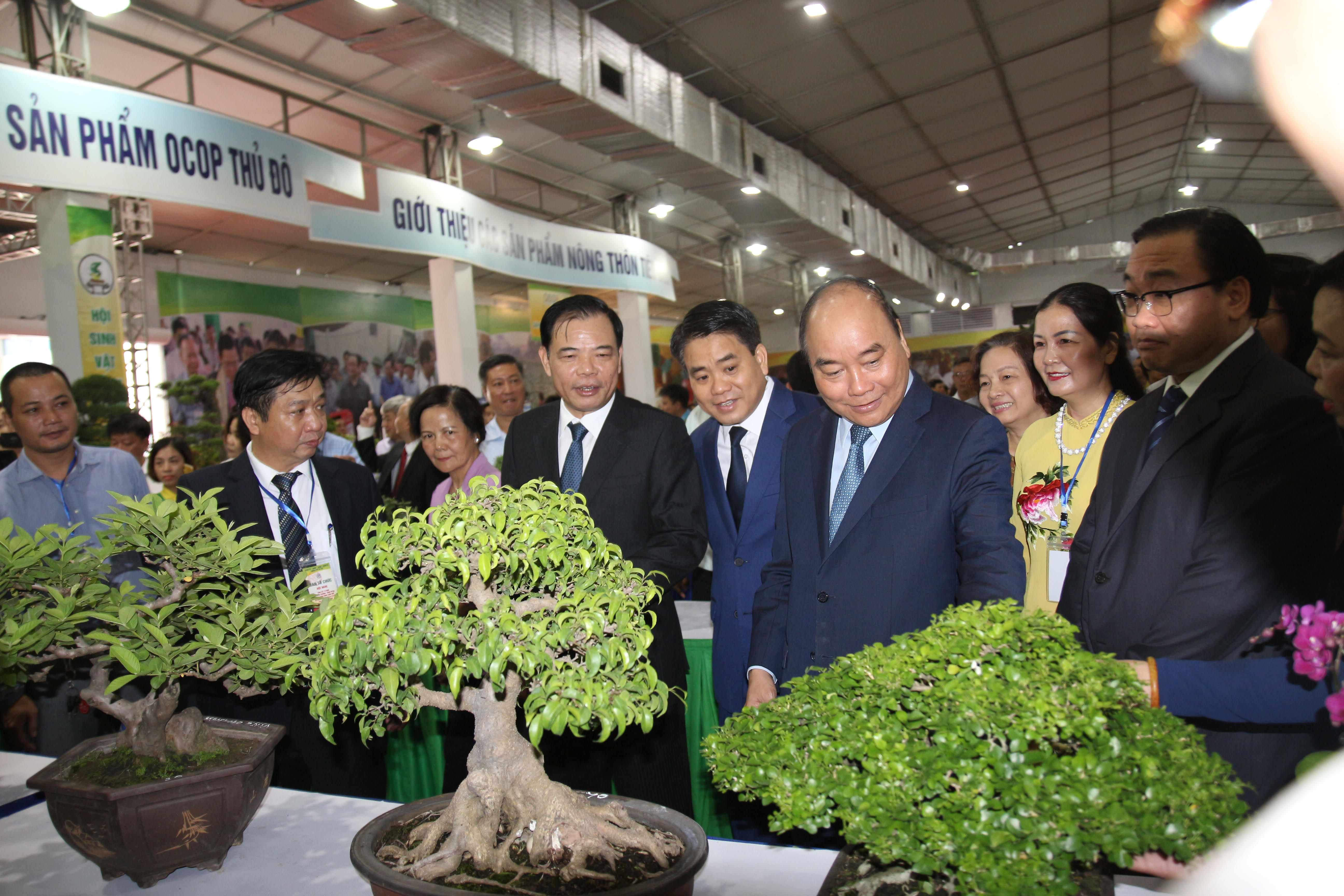 Thủ tướng Nguyễn Xuân Phúc cùng các Đại biểu tham dự Hội nghị thăm các gian hàng tại Hội chợ hàng nông sản, thủ công mỹ nghệ và sản phẩm OCOP Thủ đô.