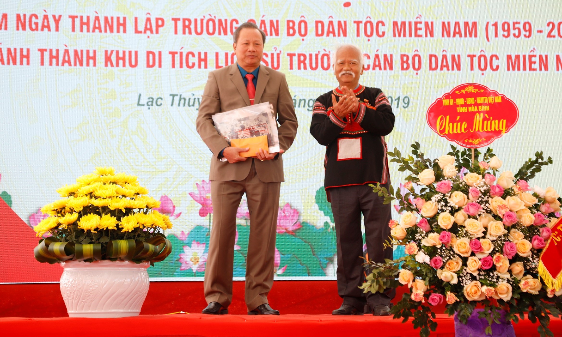Ông Ksor Phước tặng quà cho UBND huyện Lạc Thủy
