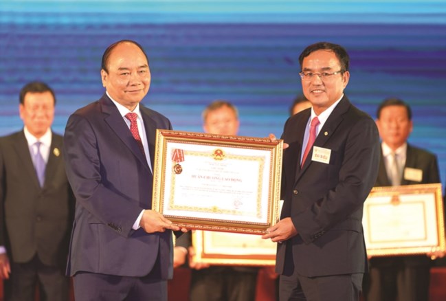 Thủ tướng Nguyễn Xuân Phúc trao Huân chương Lao động hạng Nhất cho Chủ tịch HĐTV EVN Dương Quang Thành. 