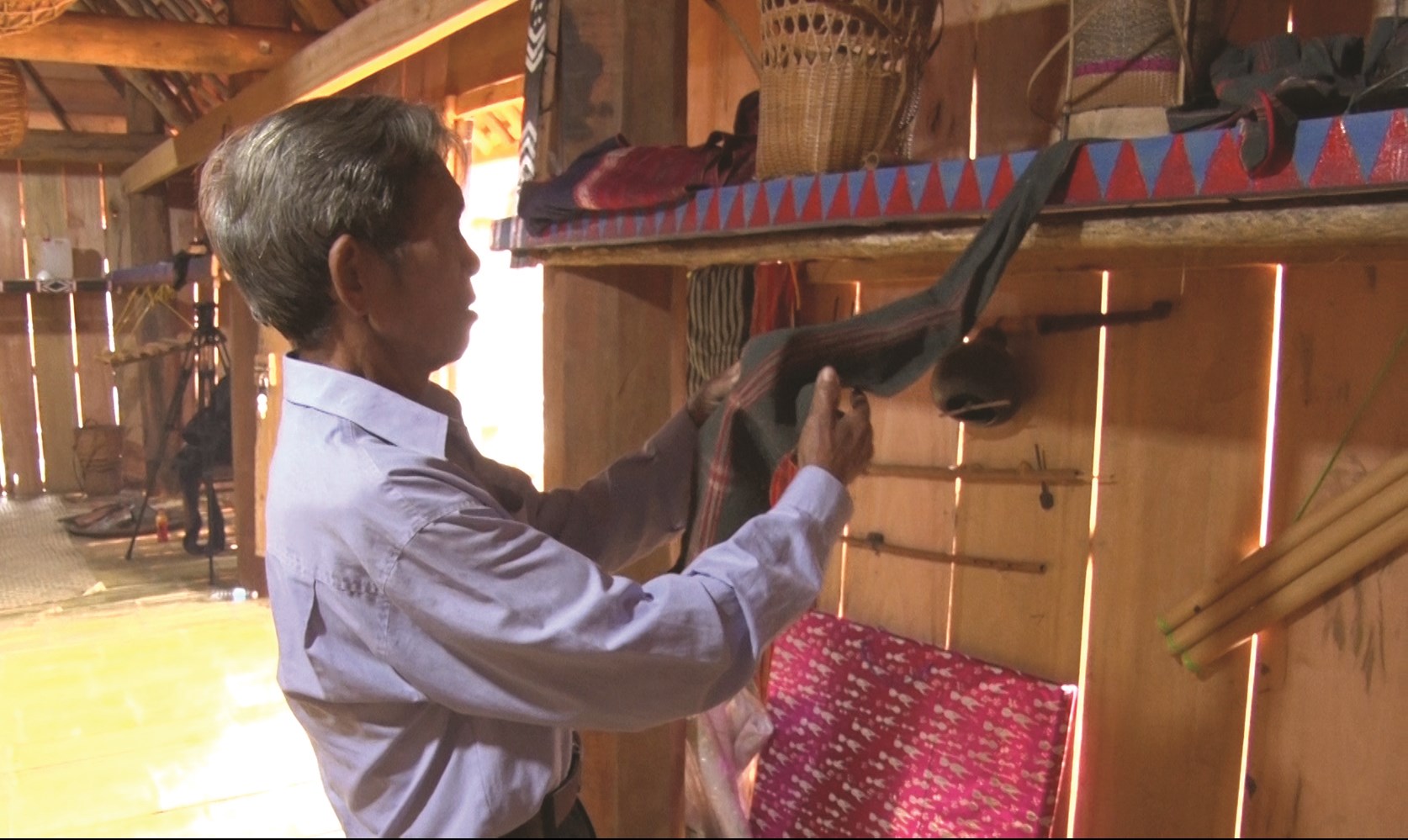 Nghệ nhân Ưu tú Đinh Y Băng - Làng M3, xã Vĩnh Thịnh sắp đặt lại những vật dụng cổ đang trưng bày tại nhà bảo tồn