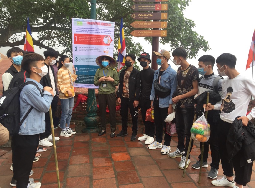Nhân viên khu du lịch Yên Tử hướng dẫn du khách thực hiện các biện pháp tự bảo vệ sức khỏe