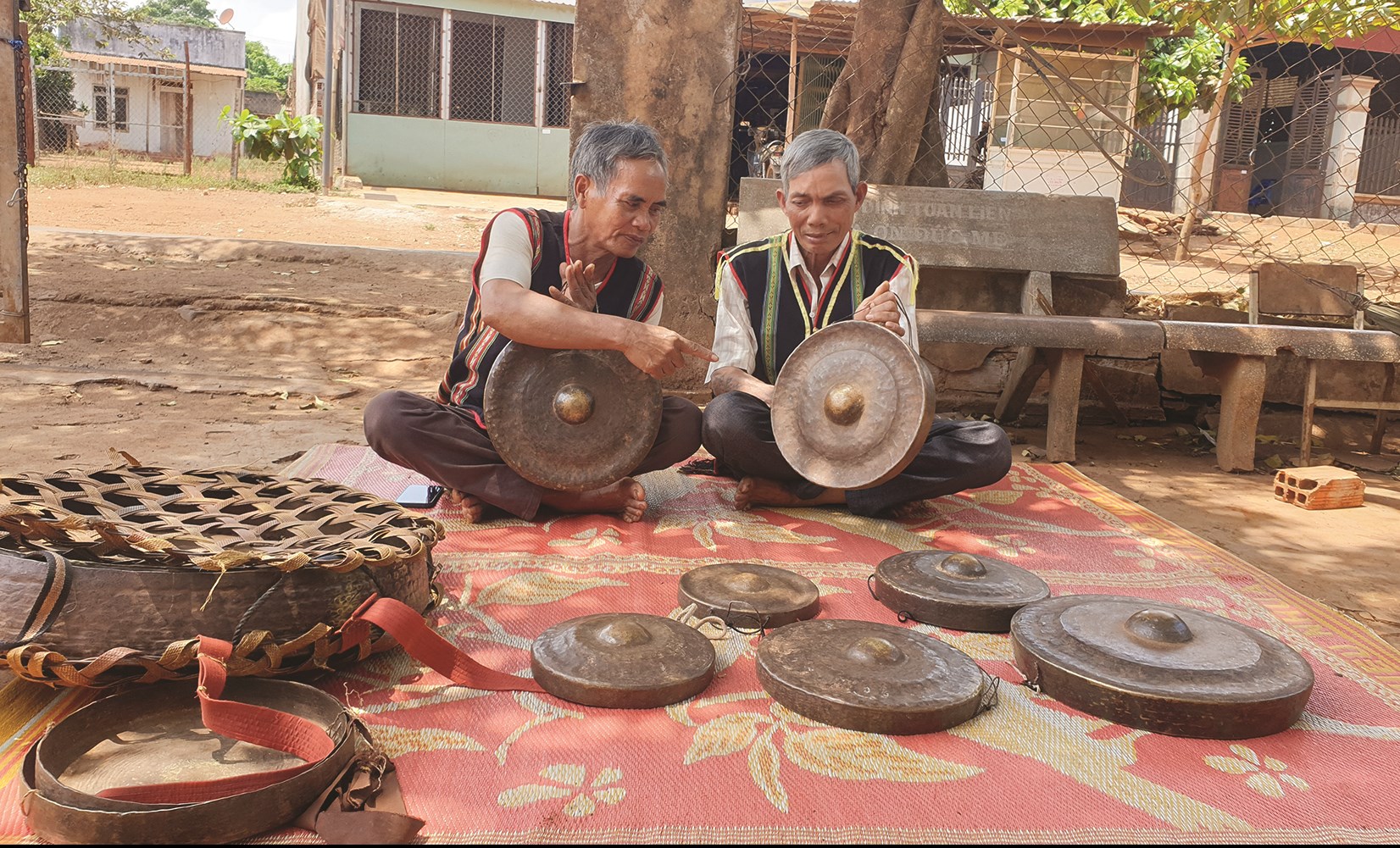 Già làng Rơ Lan Hào (trái) và thầy dạy chiêng Rah Lan Nam (phải) đang say sưa kể về tình yêu cồng chiêng của người dân làng Hăng Rinh.