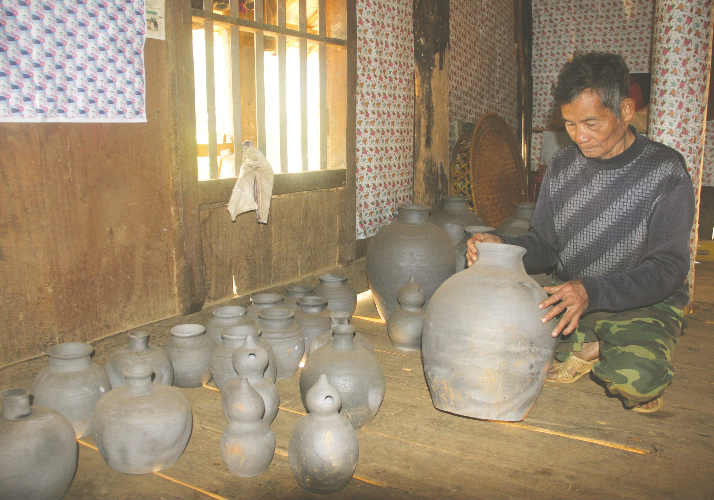 Ông Hoàng Văn Nam, bản Noong Ten, xã Mường Chanh (huyện Mai Sơn) kiểm tra các sản phẩm gốm truyền thống
