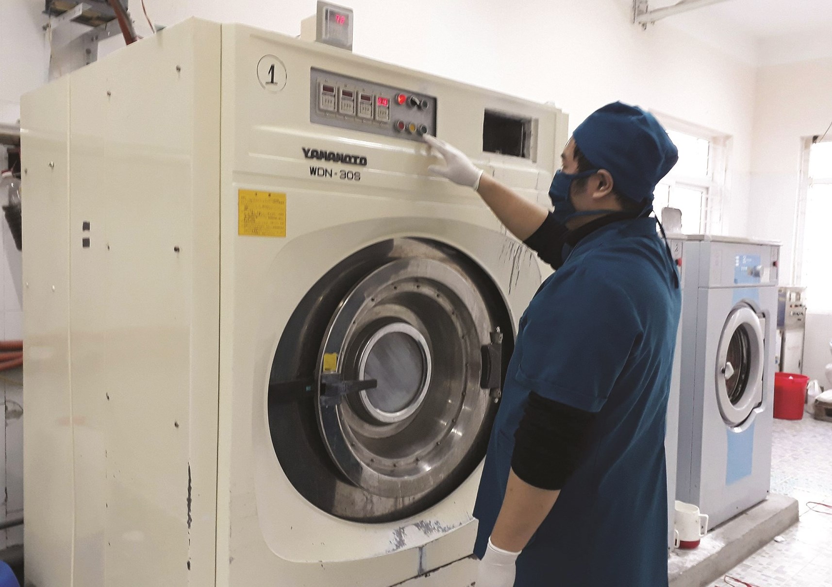 Nhân viên nhà giặt sử dụng máy giặt nhiệt độ từ 60 - 700 để xử lý đồ vải bệnh nhân nhiễm bệnh