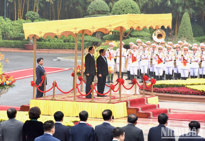Thủ tướng Phạm Minh Chính và Thủ tướng Chính phủ nước Cộng hòa Dân chủ Nhân dân Lào Sonexay Siphandone thực hiện nghi lễ chào cờ hai nước.