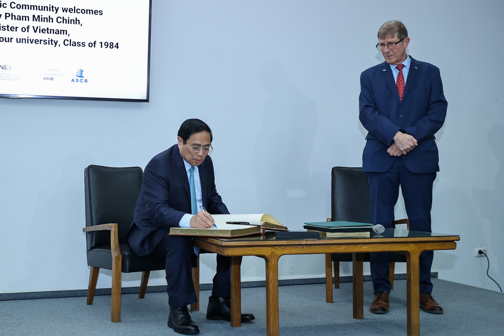 Thủ tướng ghi lưu bút khi tới thăm trường Đại học Kỹ thuật Xây dựng Bucharest - Ảnh: VGP/Nhật Bắc