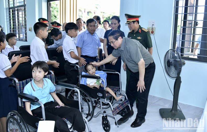 Thủ tướng Phạm Minh Chính ân cần thăm hỏi một cháu khuyết tật đang được nuôi dạy ở Trung tâm