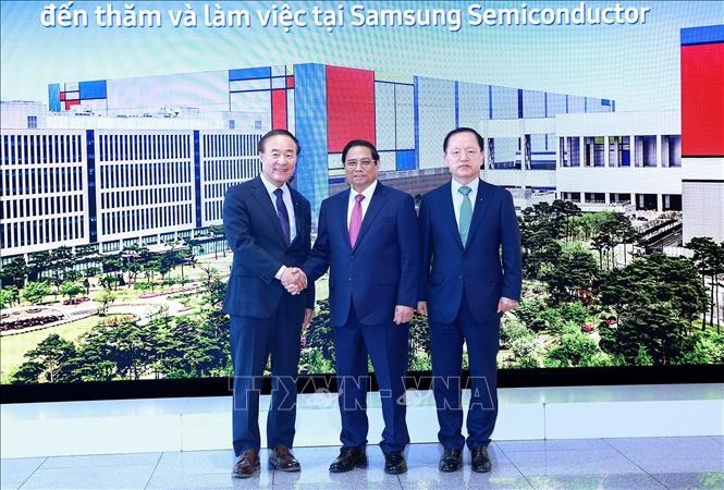 Phó Chủ tịch, Giám đốc điều hành Tập đoàn Samsung Young Hyun Jun và ông Park Hark Kyu, Tổng Giám đốc phụ trách tài chính của tập đoàn Samsung đón Thủ tướng Phạm Minh Chính. (Ảnh: Dương Giang/TTXVN)