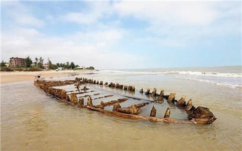 Tàu gỗ cổ ở bãi biển Hội An hiện rõ sau bão số 13