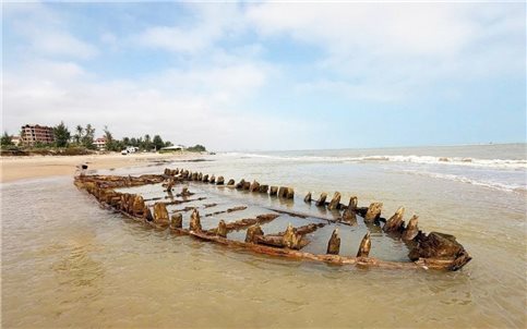 Tàu gỗ cổ ở bãi biển Hội An hiện rõ sau bão số 13