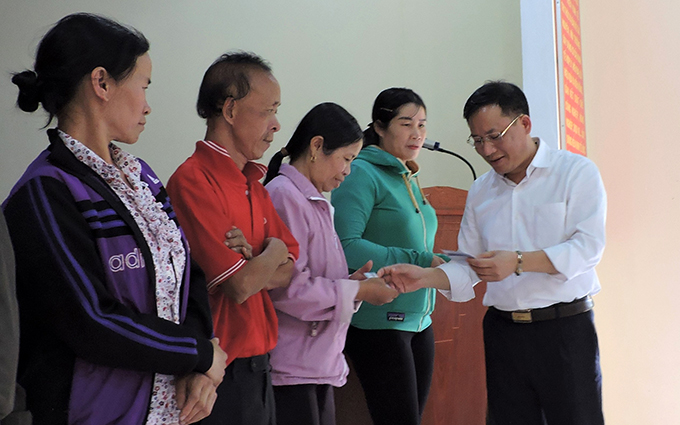 Đại diện Bảo hiểm xã hội Việt Nam trao tặng thẻ BHYT cho người dân chịu ảnh hưởng của bão số 9 tại xã Đăk Ruồng, huyện Kon Rẫy, tỉnh Kon Tum 