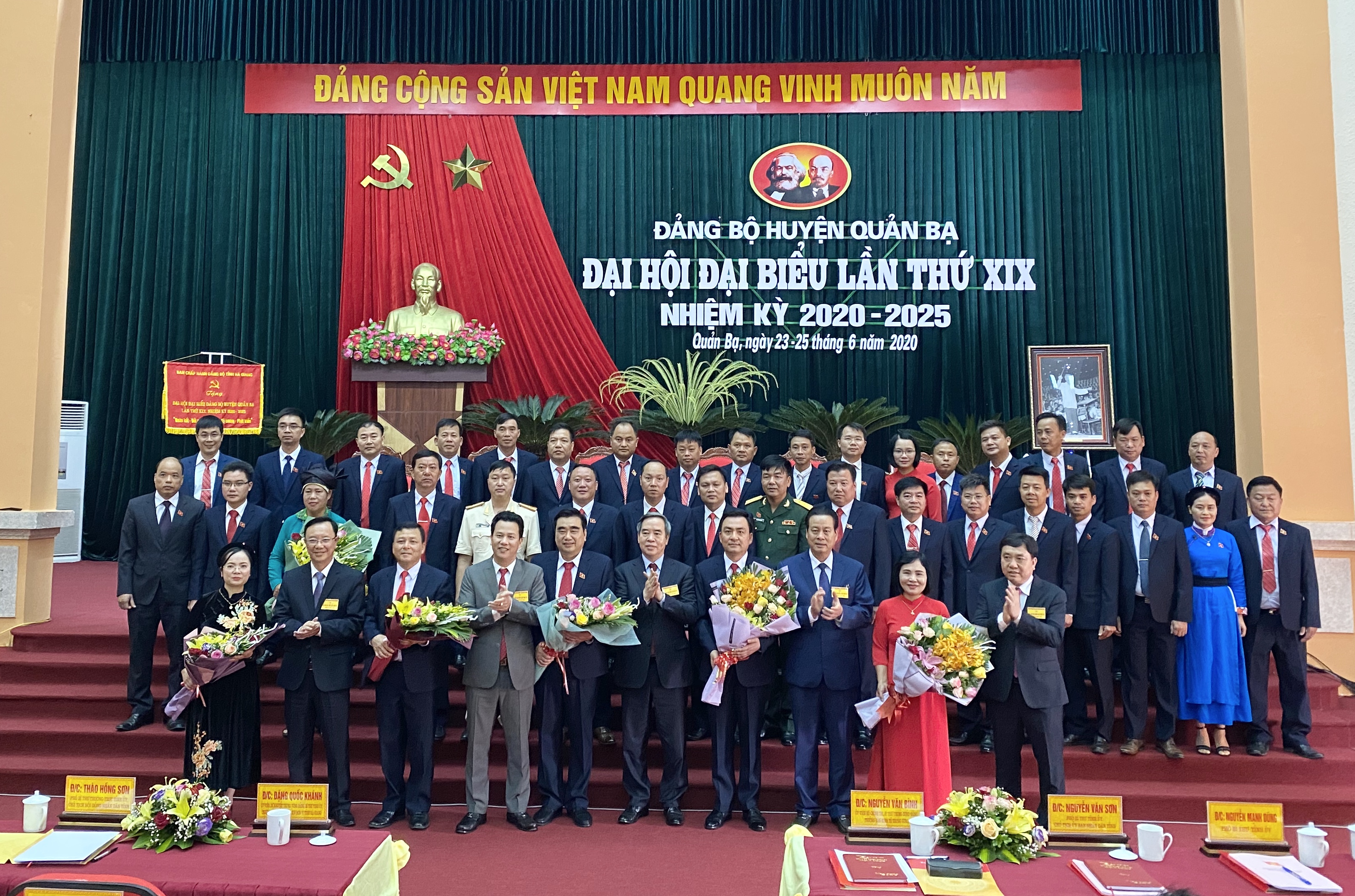 Đồng chí Nguyễn Văn Bình, Trưởng ban Kinh tế Trung ương; đồng chí Đặng Quốc Khánh, Bí thư Tỉnh ủy Hà Giang tặng hoa chúc mừng Ban Chấp hành Đảng bộ huyện Quản Bạ khóa XIX, nhiệm kỳ 2020 – 2025.