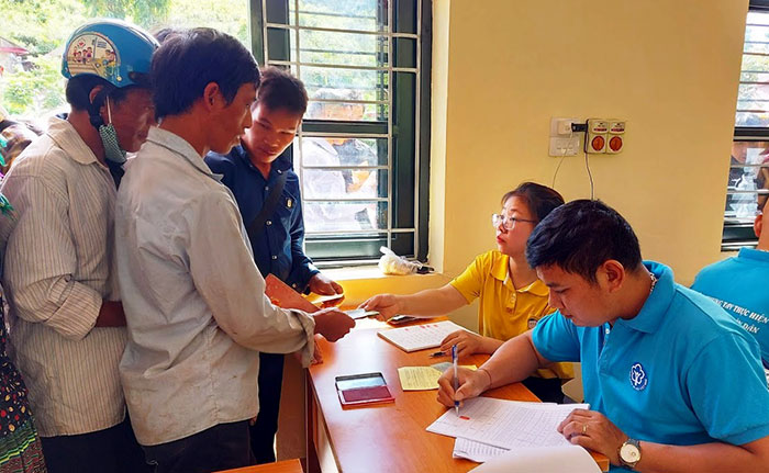 Cán bộ Bưu điện, Bảo hiểm xã hội huyện Nậm Pồ chi trả tiền hỗ trợ cho hộ nghèo, cận nghèo xã Vàng Đán bị ảnh hưởng do dịch bệnh Covid-19.