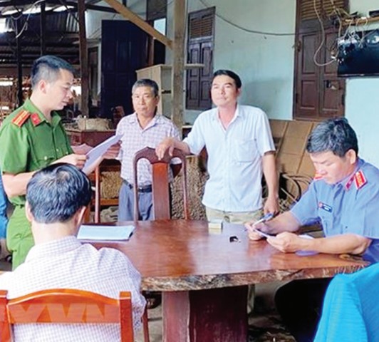 Cơ quan CSĐT đọc quyết định bắt Nguyễn Quốc Hùng (thứ 2 bên phải, mặc áo trắng).
