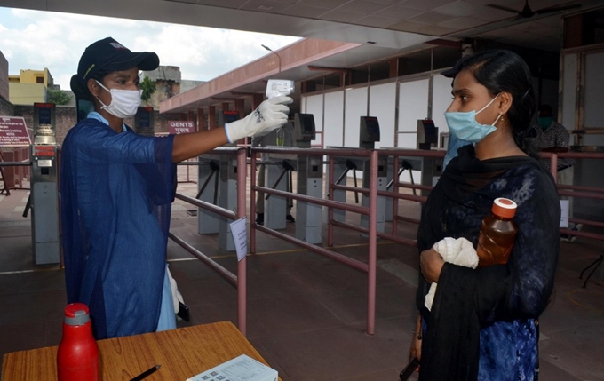 Nhân viên y tế kiểm tra thân nhiệt khách thăm quan tại một địa điểm du lịch của Ấn Độ, ngày 23/9/2020. (Ảnh: Xinhua) 