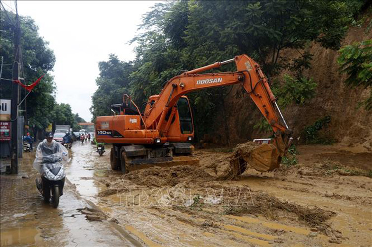 Lực lượng chức năng huyện Bát Xát (Lào Cai) khắc phục sạt lở đất gây ách tắc giao thông tại xã Quang Kim. Ảnh: Quốc Khánh - TTXVN