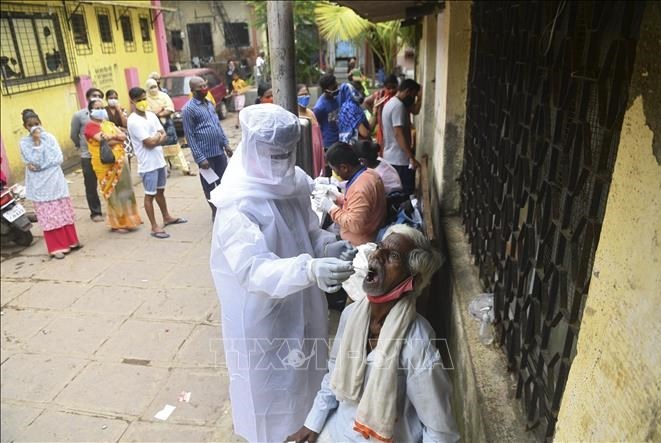Nhân viên y tế lấy mẫu dịch xét nghiệm COVID-19 cho người dân tại Mumbai, Ấn Độ, ngày 12/10/2020. Ảnh: AFP/TTXVN 