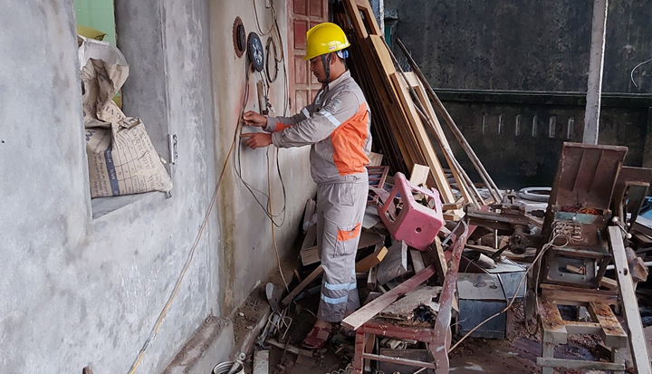 Công nhân Điện lực Cẩm Xuyên hỗ trợ kiểm tra thiết bị điện trong nhà cho người dân