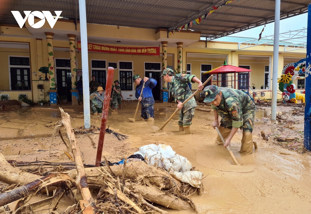 Bộ đội giúp các nhà trường dọn bùn đất sau lũ.