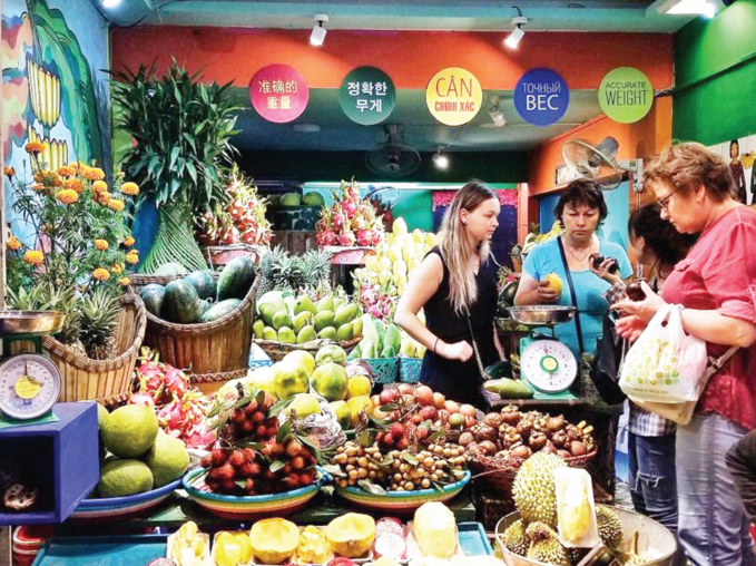 Du khách quốc tế đi mua hoa trái tại chợ đêm Nha Trang. Ảnh TL