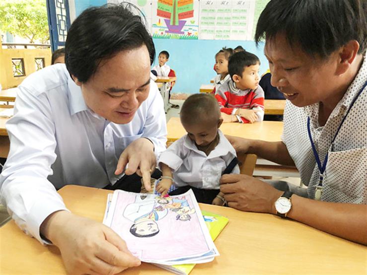 Bộ trưởng Phùng Xuân Nhạ trong một lần thăm học sinh Đinh Văn K’rể. Ảnh: MOET.