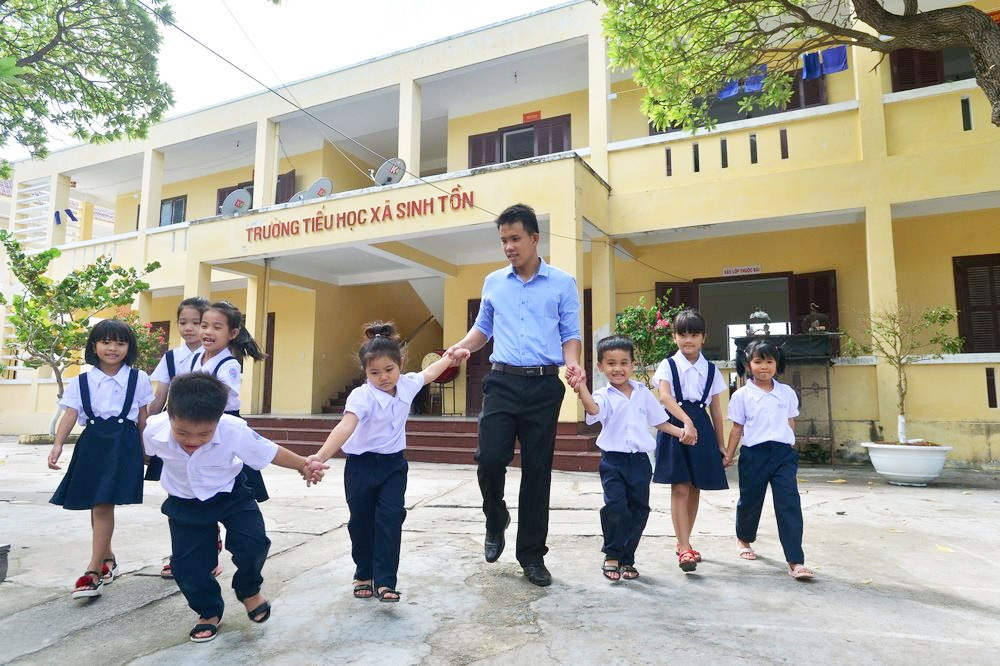 Thầy giáo Nguyễn Công Qua cùng lũ trẻ trên đảo Sinh Tồn. Ảnh: Đức Thành