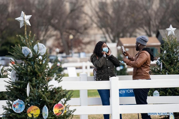Người dân đeo khẩu trang khi tới ngắm Cây thông Giáng sinh quốc gia tại khu vực gần Nhà Trắng ở thủ đô Washington, D.C, Mỹ, ngày 3/12/2020. (Ảnh: Xinhua) 