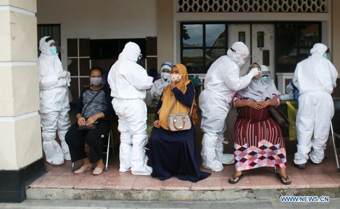 Nhân viên y tế lấy mẫu bệnh phẩm xét nghiệm COVID-19 cho phụ nữ mang thai tại Surabaya, Indonesia, ngày 8/12. (Ảnh: Xinhua)