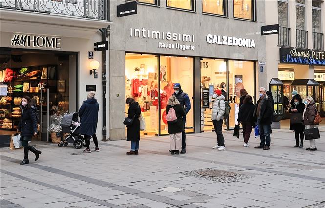 Người dân đeo khẩu trang phòng lây nhiễm COVID-19 khi xếp hàng bên ngoài một cửa hàng ở Munich, Đức, ngày 11/12/2020. Ảnh: THX/ TTXVN