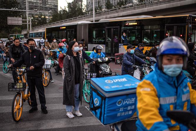 Người dân đeo khẩu trang phòng lây nhiễm COVID-19 tại Bắc Kinh, Trung Quốc, ngày 21/10/2020. Ảnh: AFP/ TTXVN