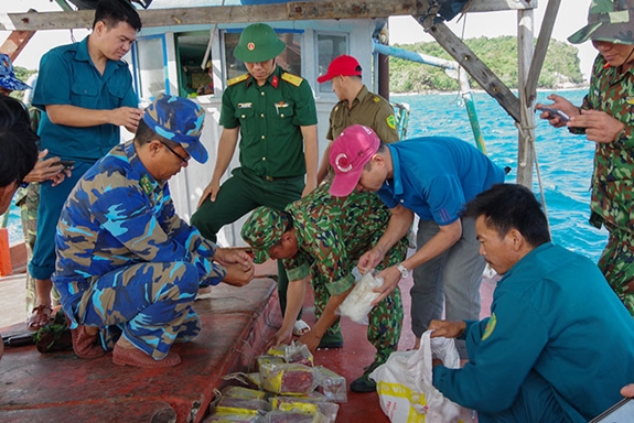 Trung đoàn 152 và lực lượng biên phòng, cảnh sát biển dùng thuyền đưa các gói nghi là ma túy từ Hòn Từ về xã đảo Thổ Châu. Ảnh: Báo QĐND 