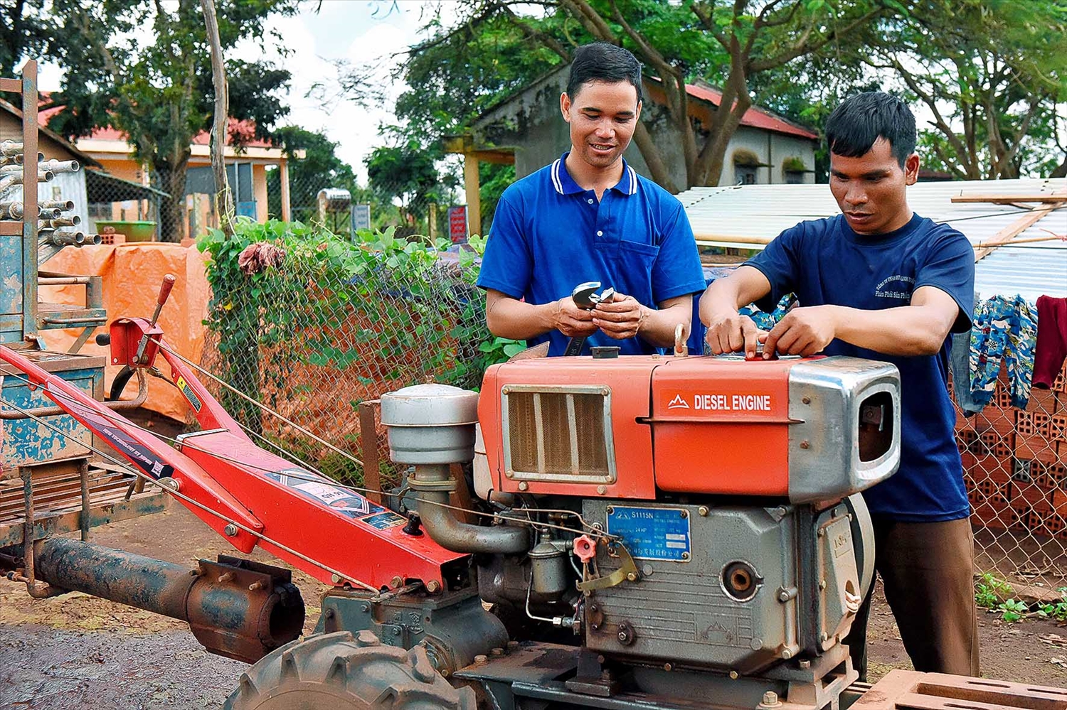 Anh Brinh (phía bên trái, xã Hnol, huyện Đak Đoa) tự sửa chữa máy móc, nông cụ sau khi tham gia lớp đào tạo nghề sửa chữa máy nông nghiệp. (Ảnh TL)