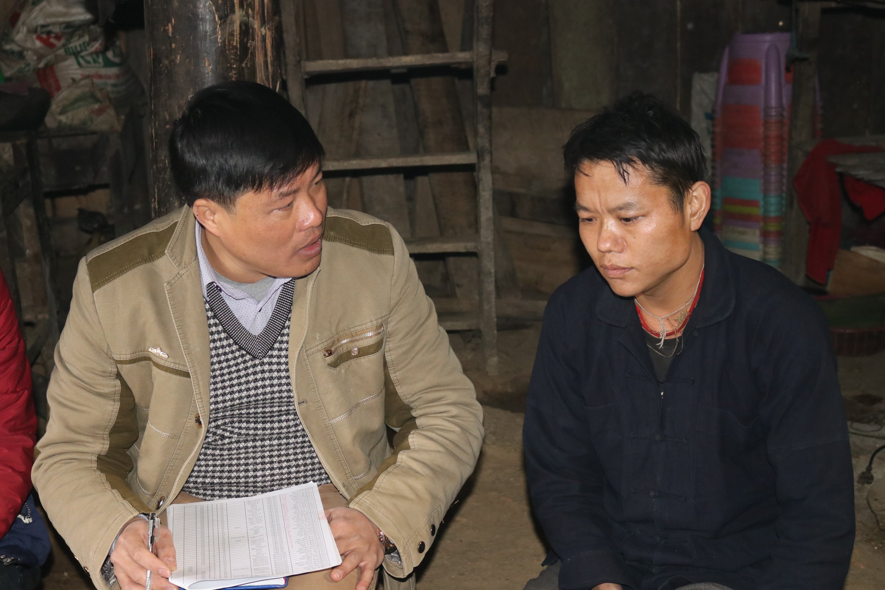 Anh Hầu Mí Na (bên phải) thôn Nà Poòng, xã Nậm Ban viết đơn xin ra khỏi hộ nghèo.