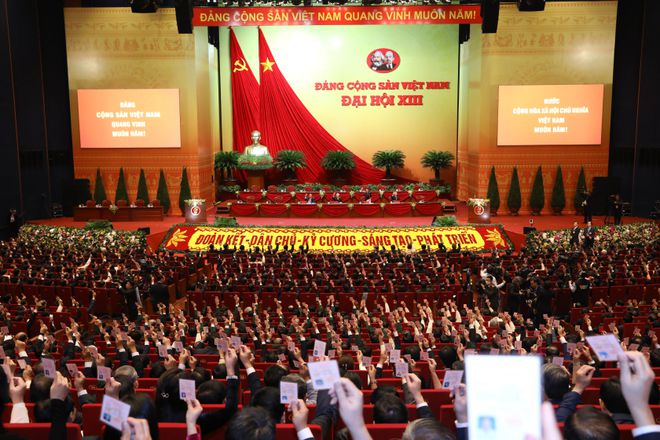 Các đại biểu biểu quyết, thông qua Nghị quyết Đại hội XIII Đảng Cộng sản Việt Nam. Ảnh: TTXVN