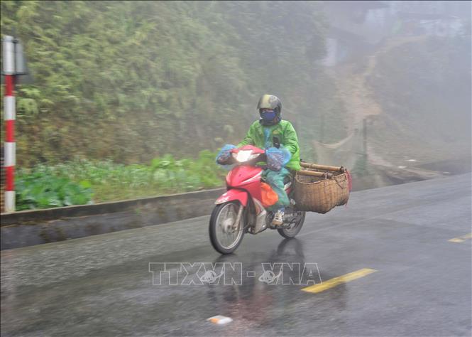 Người dân đi xe máy vận chuyển hàng hóa trong sương sớm, giá lạnh trên đỉnh đèo Pha Đin.