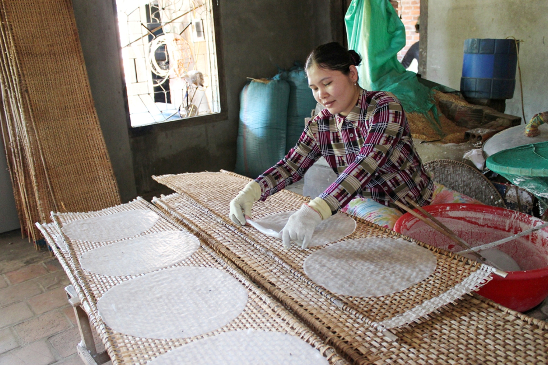 Chị Trần Ngọc Thủy ở ấp Thống Nhất (thị trấn Ngan Dừa )đang thực hiện công đoạn đưa bánh vừa tráng lên phên để phơi.