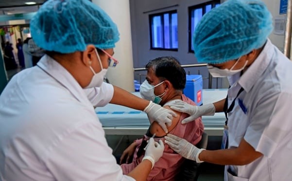  Các nhân viên y tế tiêm Vaccine phòng COVID-19 cho một bác sĩ ở Ahmedabad, Ấn Độ (Ảnh: AFP/Getty Images)