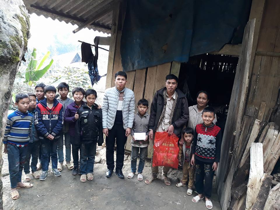 Thầy giáo Nguyễn Quốc Đại (áo khoác trắng, Hiệu trưởng Trường THCS Nậm Cang, Sa Pa, Lào Cai) tặng quà, chúc Tết học sinh nghèo.