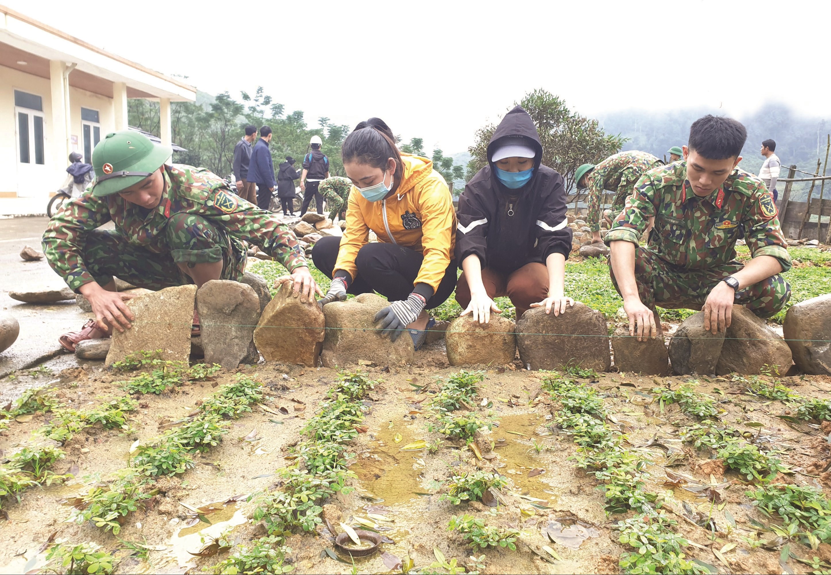 Cán bộ, chiến sĩ Lữ đoàn 414 cùng các cô giáo điểm trường mầm non xã đóng tại bản Dộ - Tà Vờng trồng hoa củng cố khuôn viên trường học.