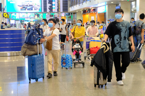 Người dân làm thủ tục đi máy bay tại sân bay Tân Sơn Nhất chiều 3-2 - Ảnh: QUANG ĐỊNH