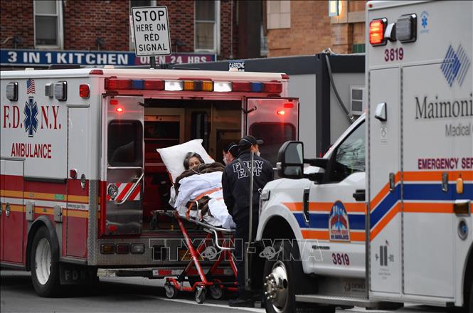 Nhân viên y tế chuyển bệnh nhân COVID-19 tới bệnh viện ở New York, Mỹ. Ảnh: AFP/TTXVN