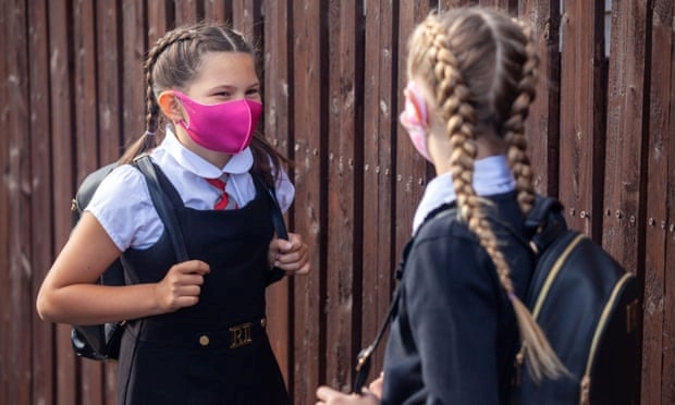 Trẻ em đeo khẩu trang khi đến trường để phòng dịch COVID-19 (Ảnh: The Guardian)