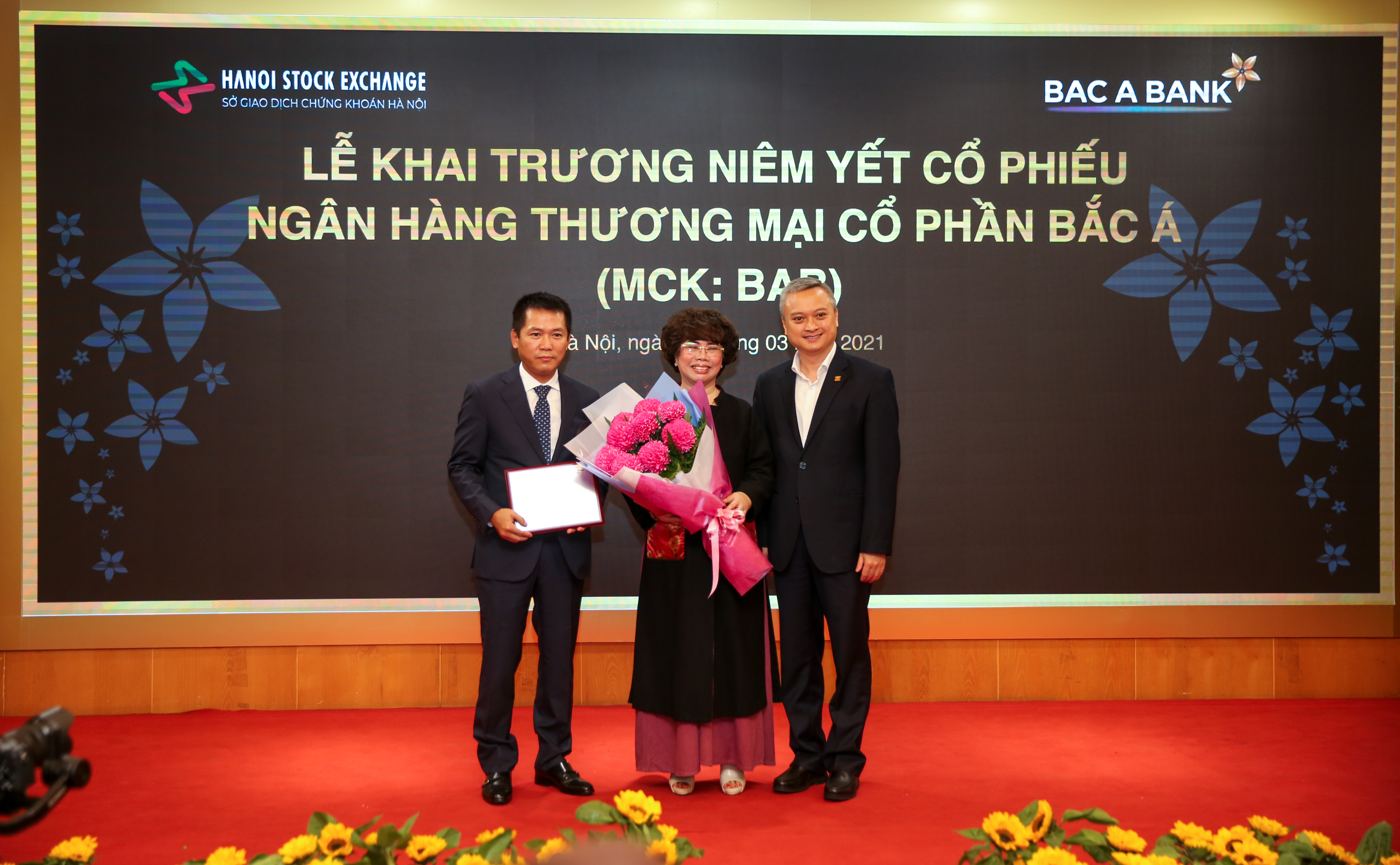Đại diện BAC A BANK nhận bảng chứng nhận niêm yết cổ phiếu và hoa chúc mừng từ Sở GDCK Hà Nội