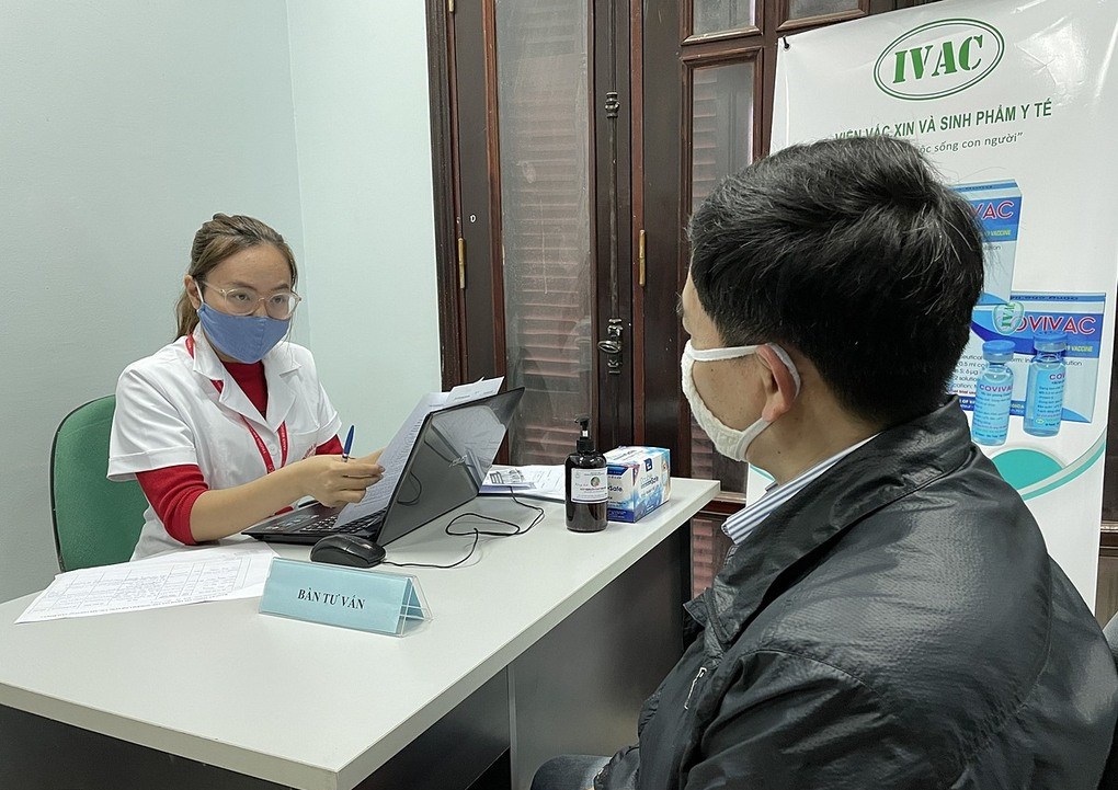Đại diện nhóm nghiên cứu (trái) tư vấn cho người đăng ký tham gia thử nghiệm vaccine, tại Trường Đại học Y Hà Nội. Ảnh: Giang Huy