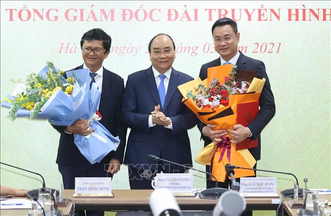 Thủ tướng Nguyễn Xuân Phúc tặng hoa cho tân Tổng Giám đốc Đài Truyền hình Việt Nam Lê Ngọc Quang và nguyên Tổng Giám đốc Trần Bình Minh.