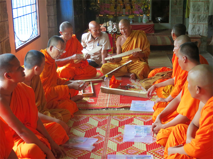 Hòa thượng Chau Sơn Hy (thứ 6 từ trái sang) hướng dẫn các sư sãi viết kinh lá buông. Ảnh: Đăng An