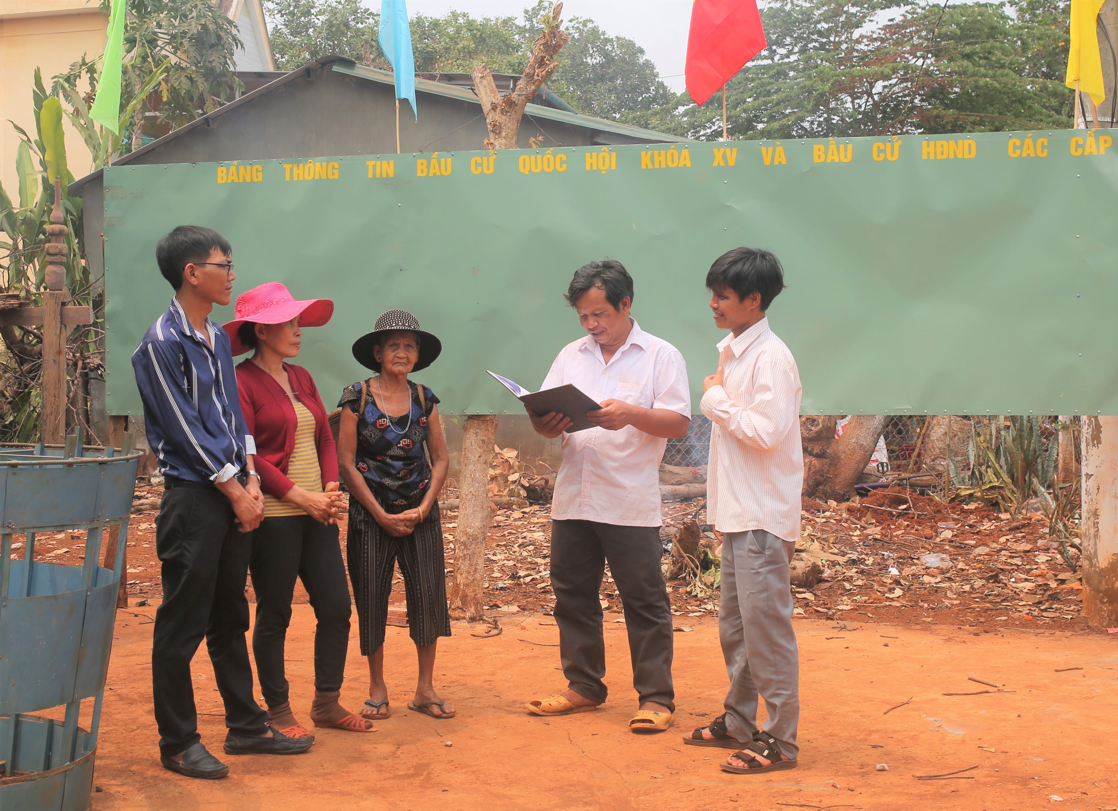 Ông Siu Lich, Trưởng ban Công tác Mặt trận làng Ếch (thứ 2 từ phải qua) đang trao đổi với người dân về công tác bầu cử.