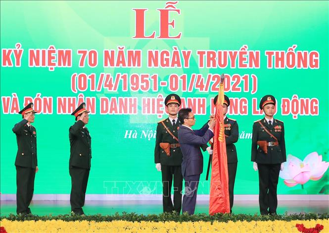 Thay mặt lãnh đạo Đảng, Nhà nước, Phó Thủ tướng Vũ Đức Đam gắn Danh hiệu Anh hùng Lao động thời kỳ đổi mới lên lá cờ truyền thống của Bệnh viện Trung ương Quân đội 108. Ảnh: TTXVN
