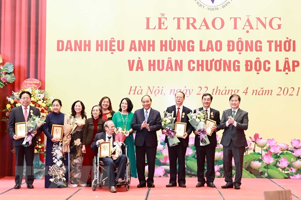 Chủ tịch nước Nguyễn Xuân Phúc tặng chân dung Chủ tịch Hồ Chí Minh cho đại diện gia đình và các cá nhân tại buổi lễ. (Ảnh: Thống Nhất/TTXVN)