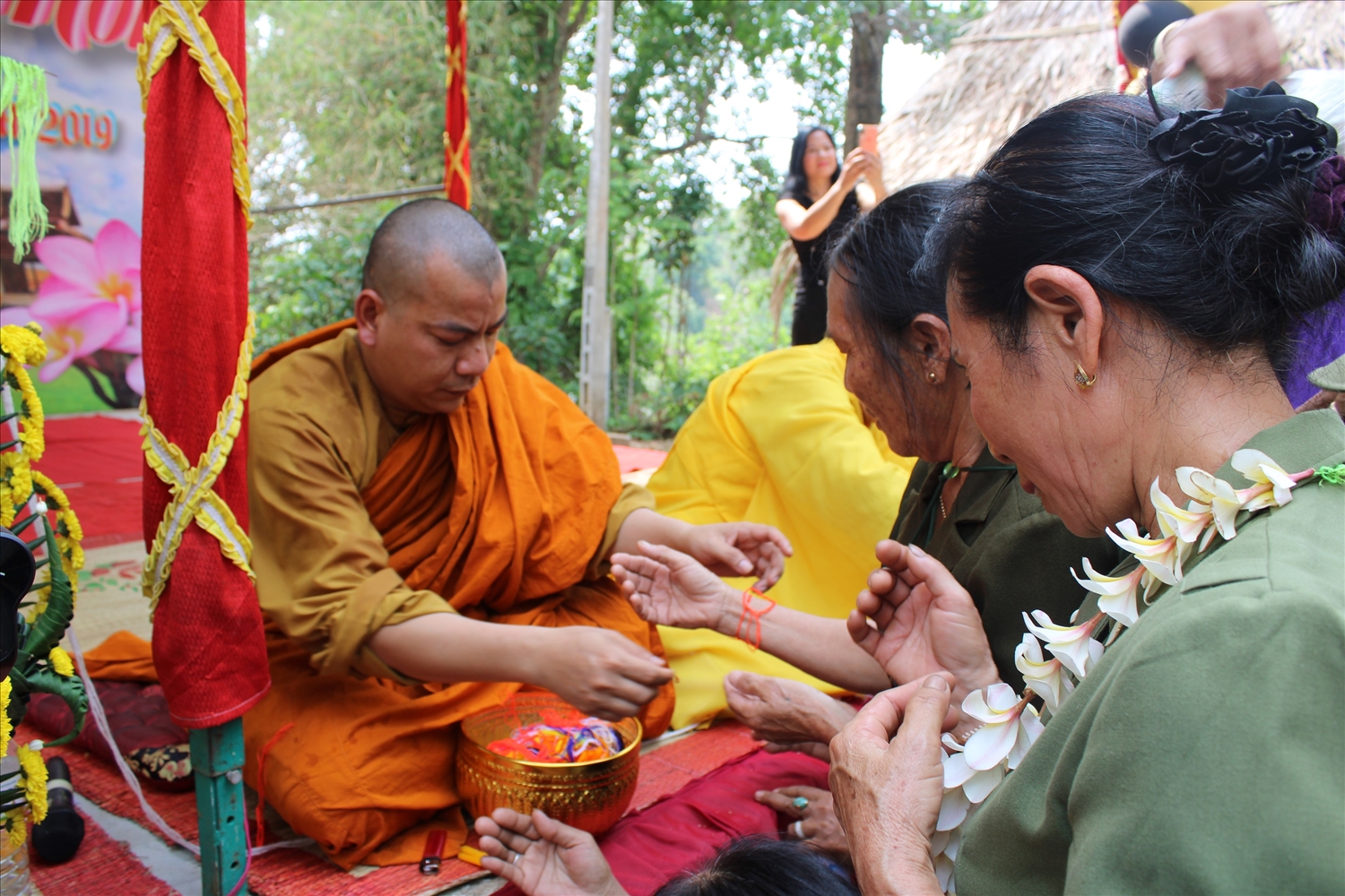 Lễ tắm phật và buộc chỉ đỏ vào cổ tay trong ngày Tết truyền thống Bunpimay của người Lào
